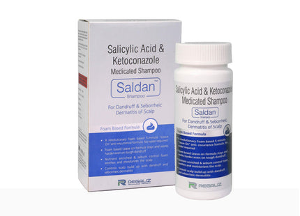 A bottle of SALDAN shampoo next to its packaging box. The packaging is primarily white and blue with text detailing the product name, purpose, and instructions.